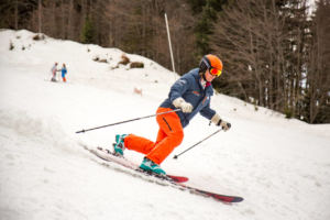 woman telemark skiing down a snowy hill