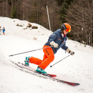 woman telemark skiing down a snowy hill