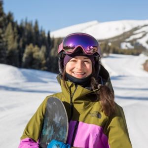 snowboarder smiling while holding snowboard