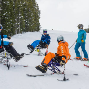 group of sliders and riders in regular and adaptive equipment talking in a circle