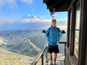 man standing on deck with mountainous background