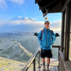 man standing on deck with mountainous background