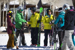 Skiers standing around on snow shaking hands