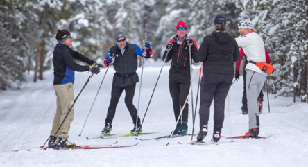 group of skiers standing in a circle in the snow