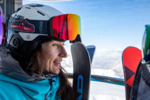 smiling woman skier on gondola looking out the window