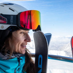 smiling woman skier on gondola looking out the window