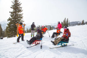 adaptive riders and sliders on snowy mountain