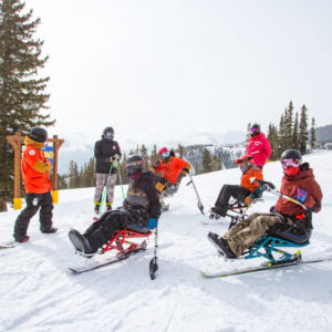 adaptive riders and sliders on snowy mountain