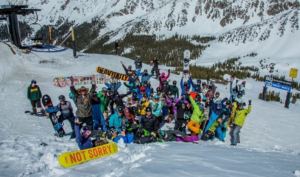group of snowboarders standing together on the snow