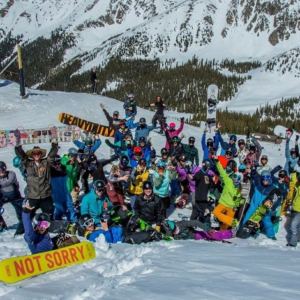 group of snowboarders standing together on the snow