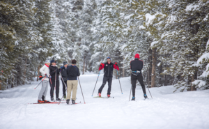 group of skiers standing in a circle laughing.