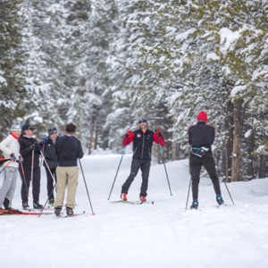 group of skiers standing in a circle laughing.